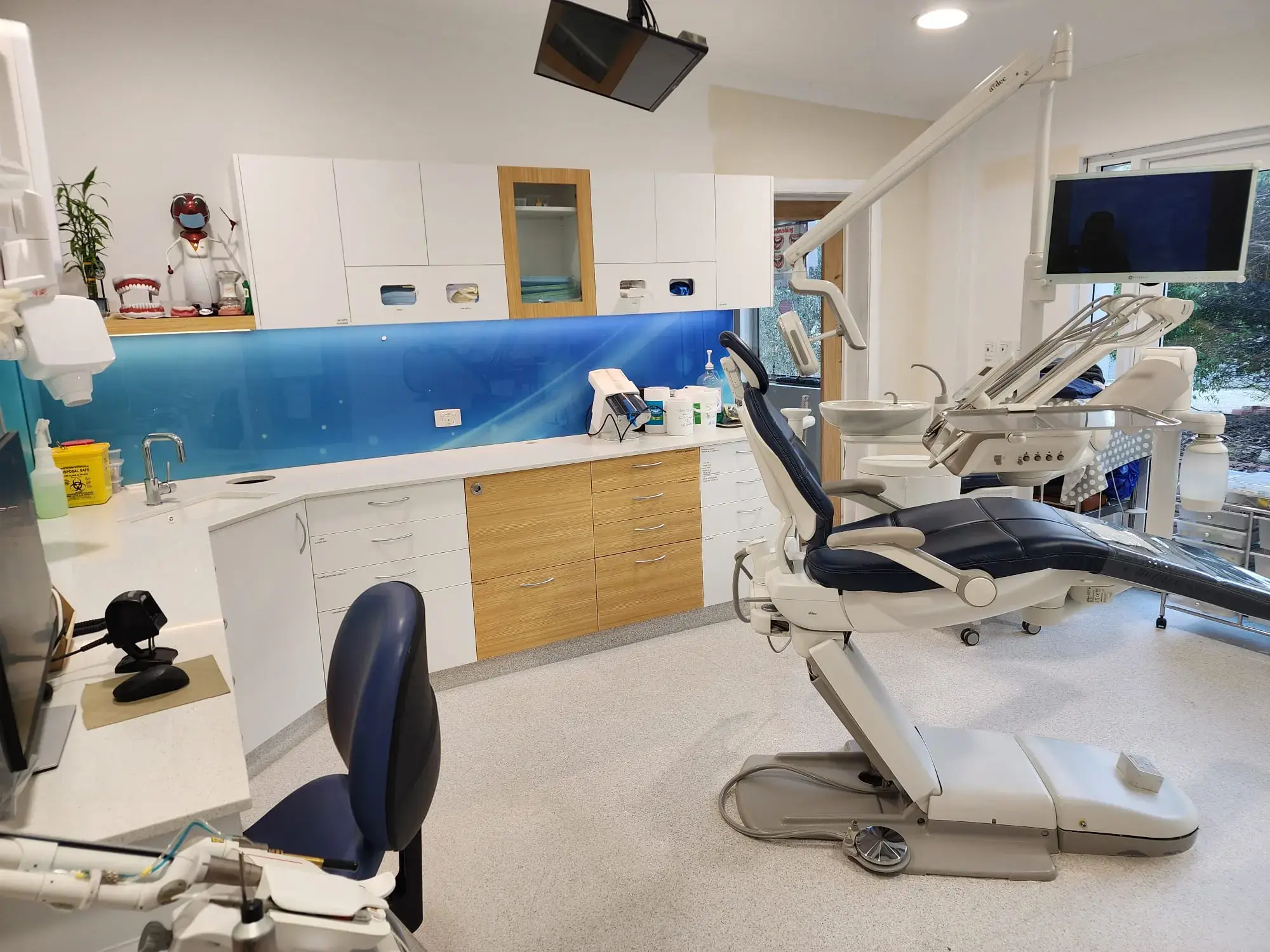A treatment room at Hocking Dental Care, with the chair, overhead light and patient screen